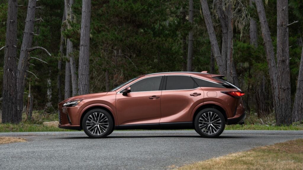 Lexus RX i kopparfärg parkerad vid skogsväg