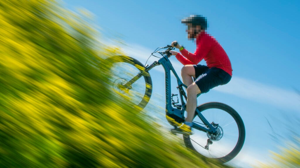 Elcyklist på väg upp för backe.