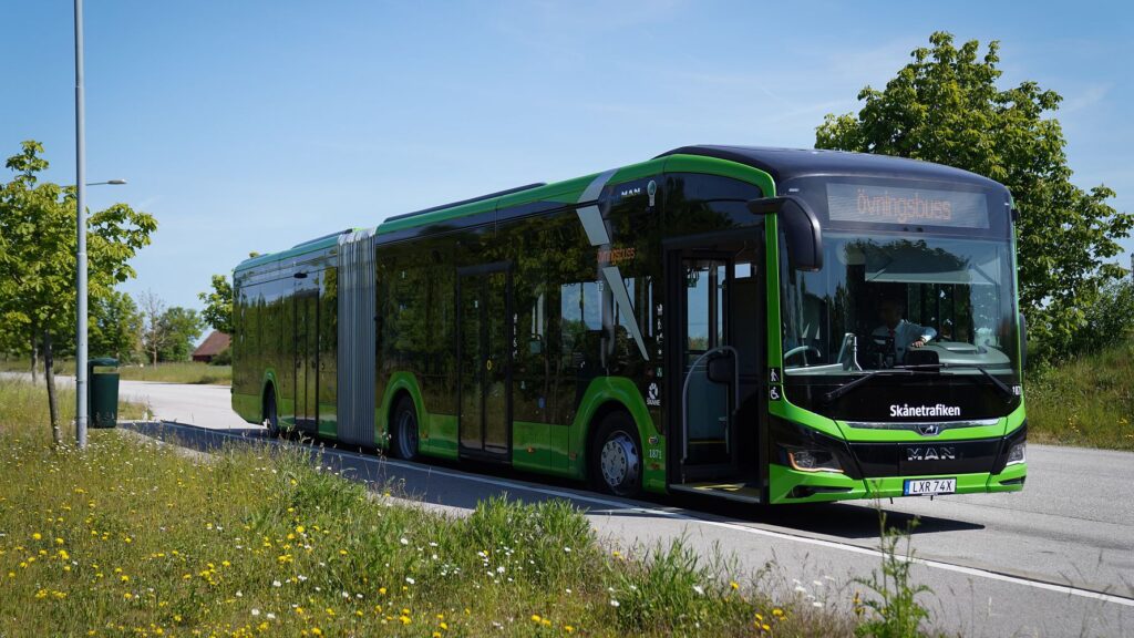 Grön regionbuss från Skånetrafiken står stilla vid hållplats i Skåne.