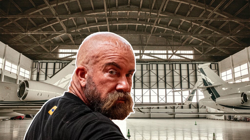 Jan Emanuel inklippt på en bild på en flyghangar.