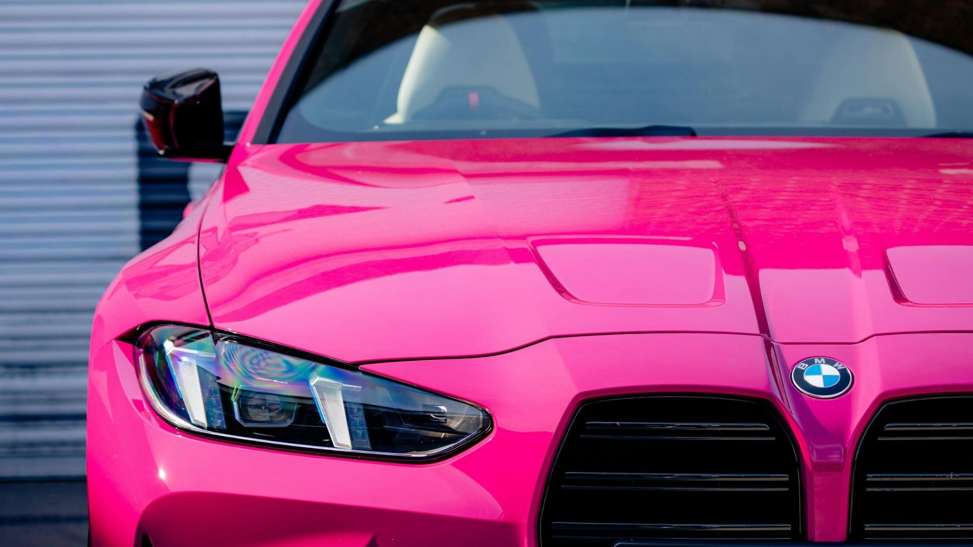 Närbild på en BMW i stark rosa lack.