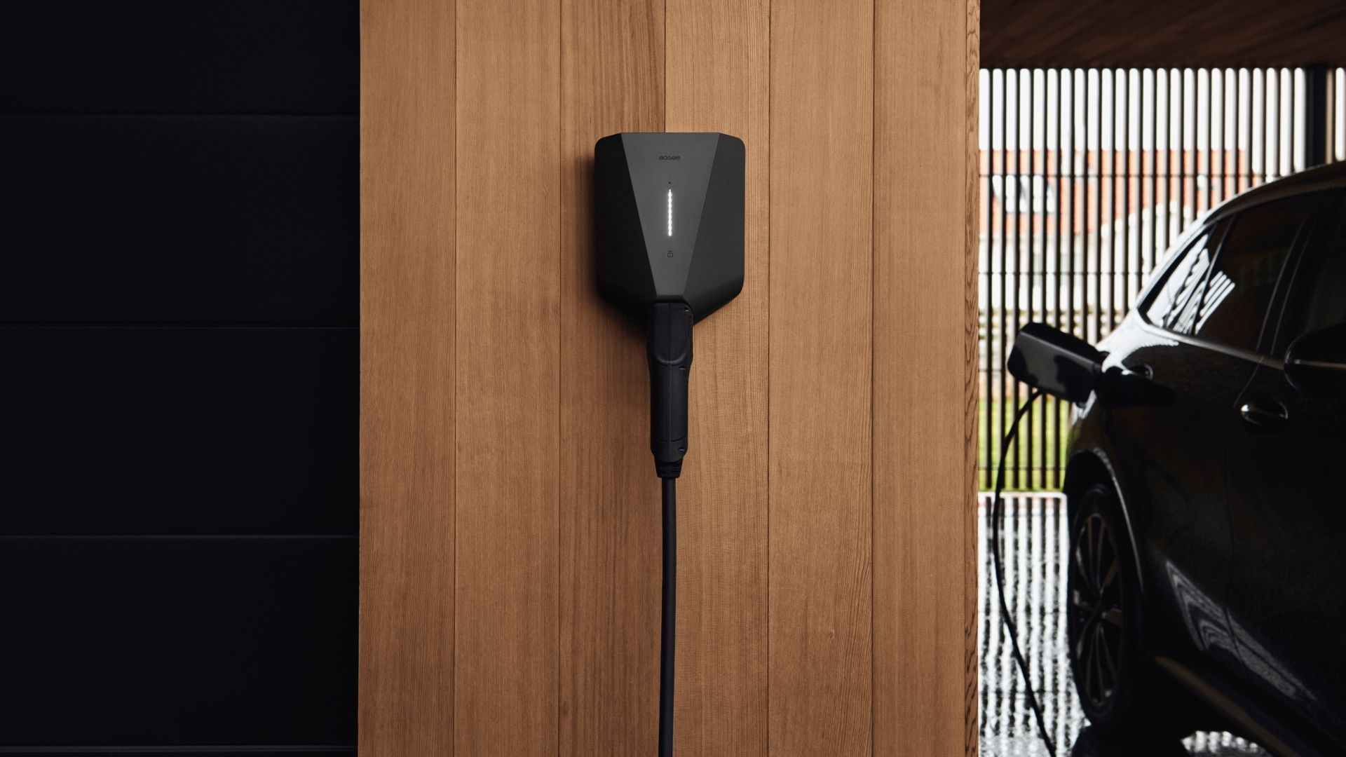 Easee Home laddbox monterad på trävägg bredvid elbil