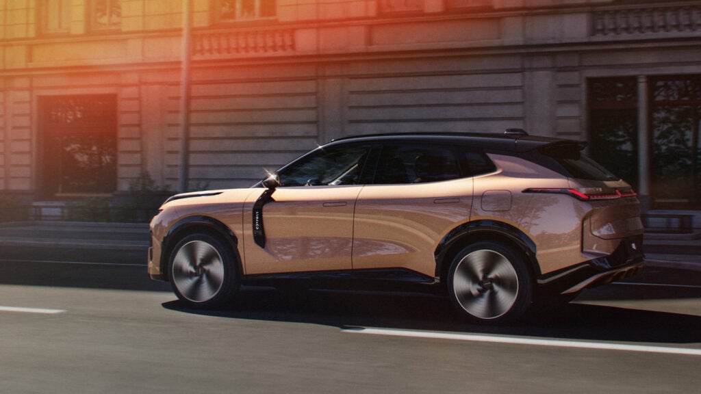 Champagnefärgad Lynk & Co 08 från sidan i stadsmiljö.