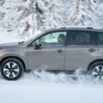 Grå Subaru Forester i profil kör i snö.