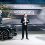 Audi-chef Gernot Döllner står på scen mellan två SUV-modeller under presentation
