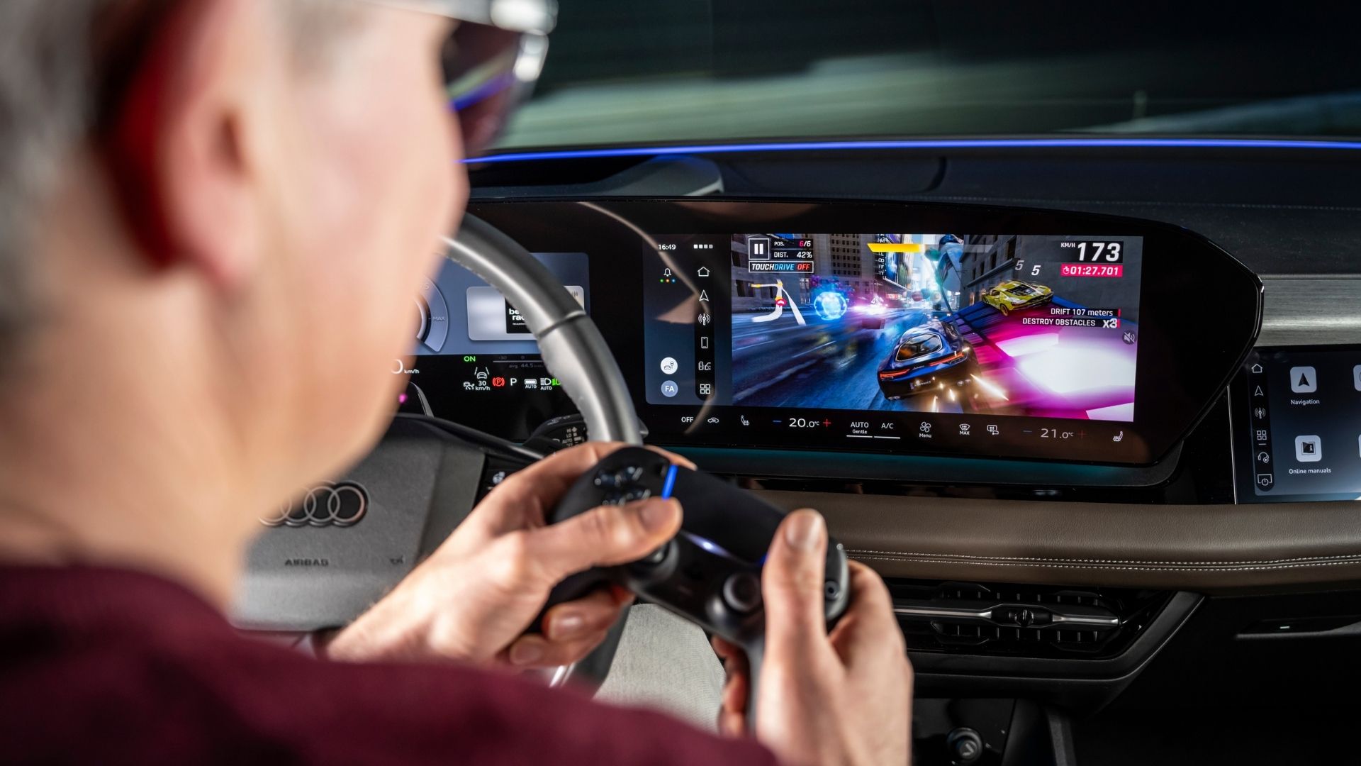 Person som spelar bilspel via handkontroll på Audis stora mittskärm