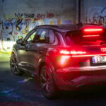 Audi Q3 e-hybrid sedd bakifrån med graffitivägg i bakgrunden.