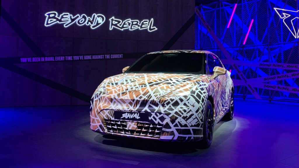 Kamouflerad Cupra Raval snett framifrån i studiomiljö.