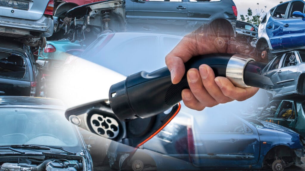 Skrotbilar och elbil som laddas.