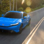 Racingblå Honda Prelude snett framifrån kör på landsväg.