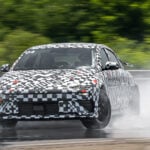 Kamouflerad Hyundai Ioniq 6 N kanar på vatten.