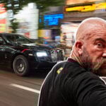 Jan Emanuel inklippt på en bild på en svart Rolls-Royce Wraith i Tokyo.
