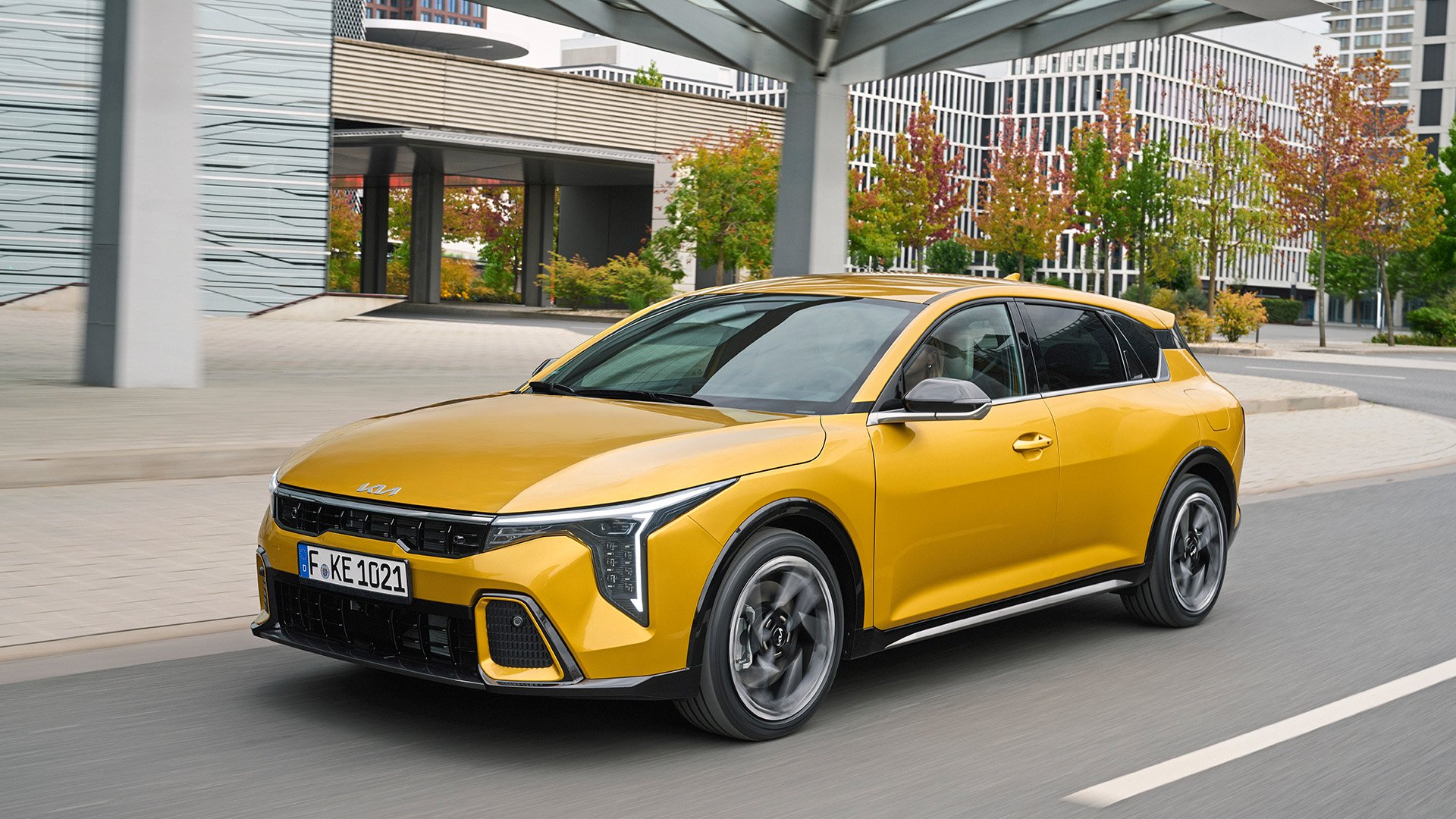 Kia K4 i Sparkling Yellow I urban miljö.