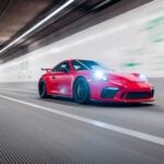 Röd Porsche 911 GT3 kör i hög fart genom tunnel