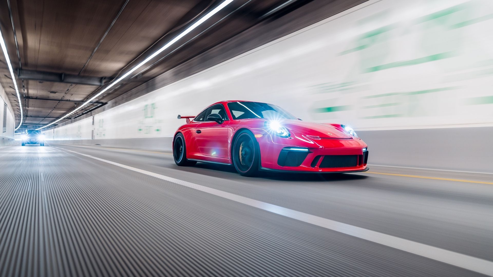 Röd Porsche 911 GT3 kör i hög fart genom tunnel