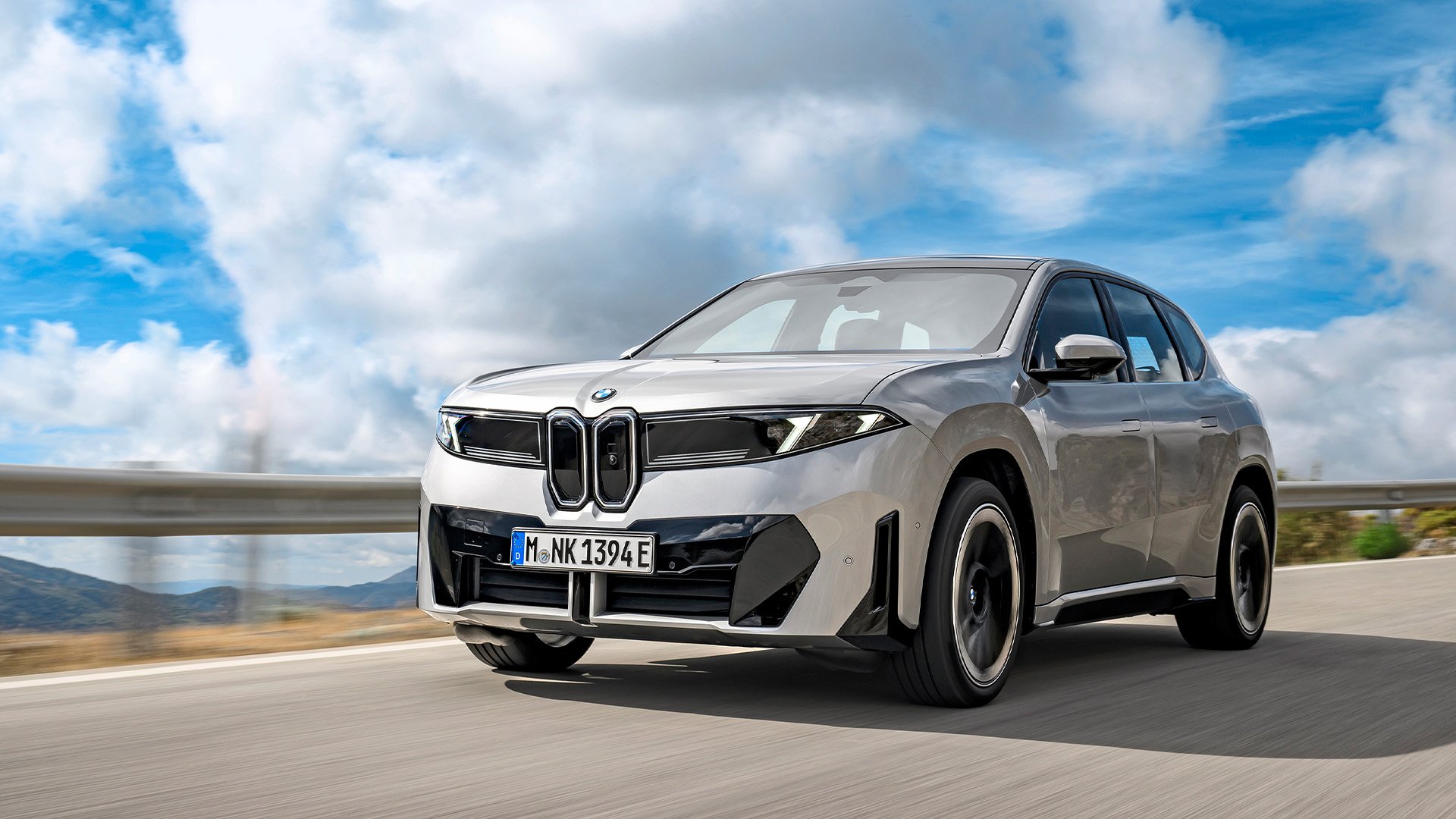 Grå BMW iX3 Neue Klasse på väg snett framifrån.