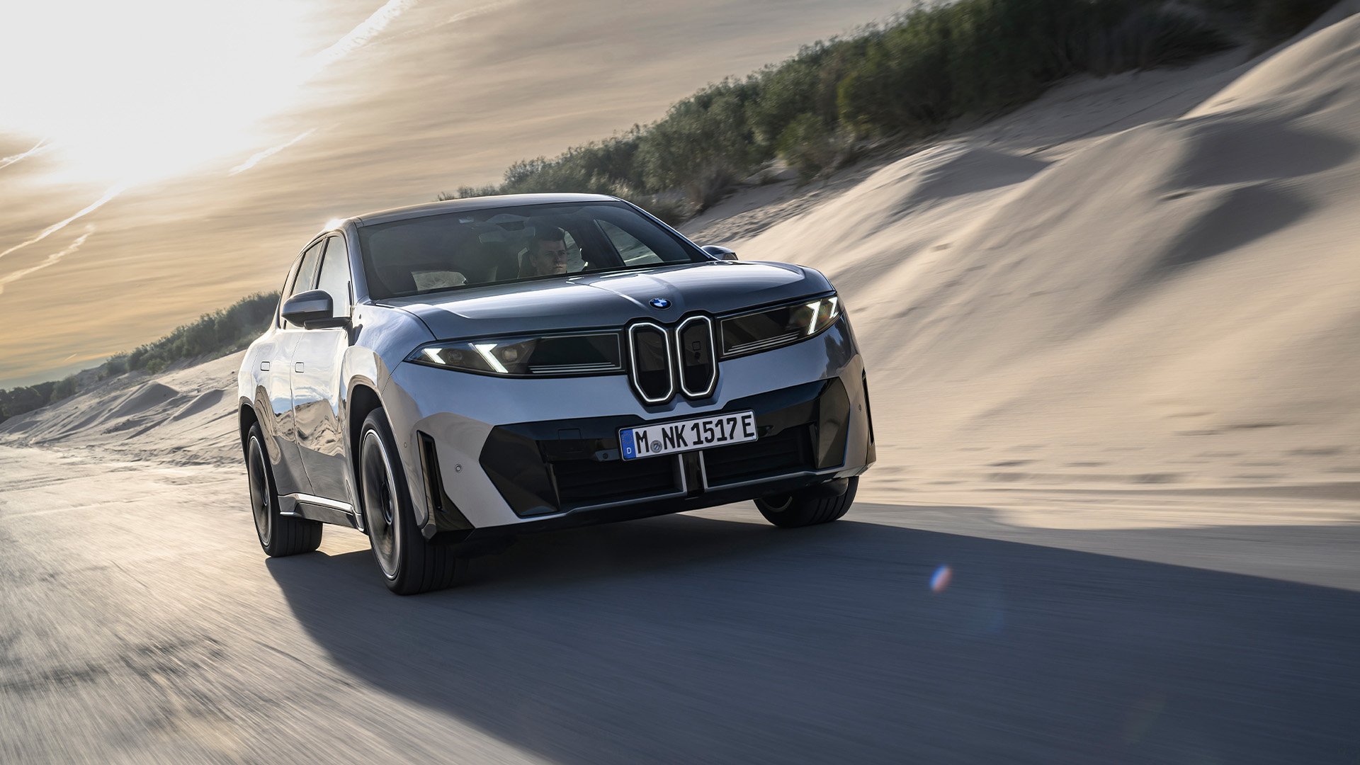 Grå BMW iX3 Neue Klasse på väg snett framifrån.