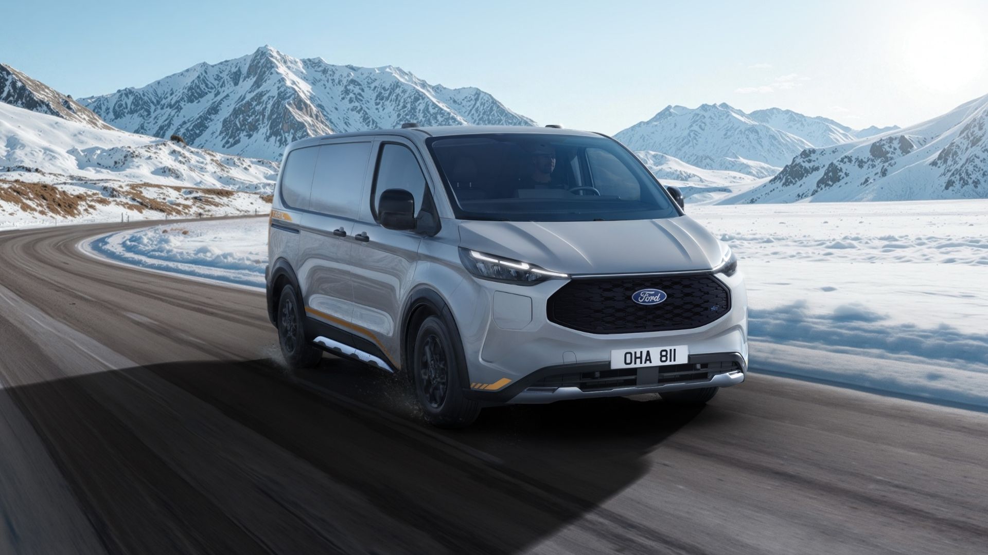 Ford E-Transit Custom AWD kör på vinterväg i snölandskap