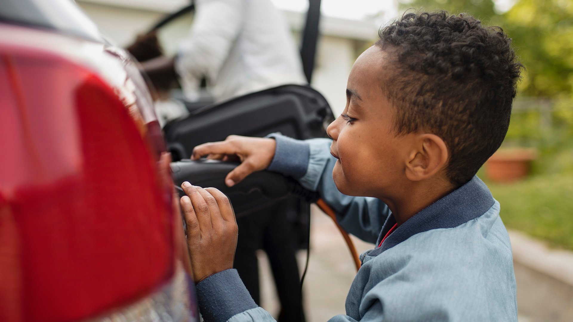 Liten pojke sätter in laddsladden