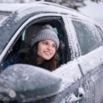 Tjej tittar ut ur snöig bil
