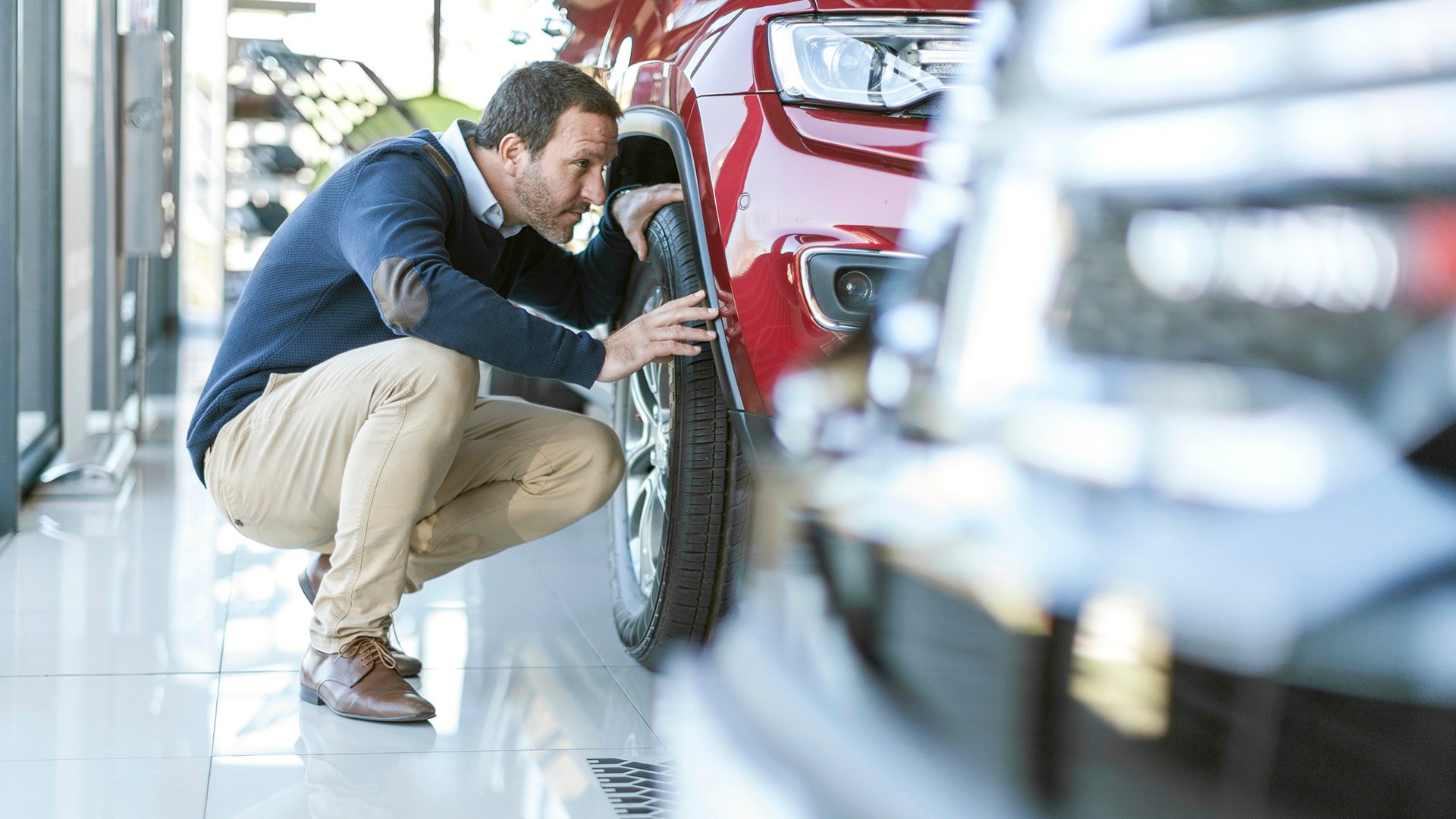 Man examining new car at car dealership