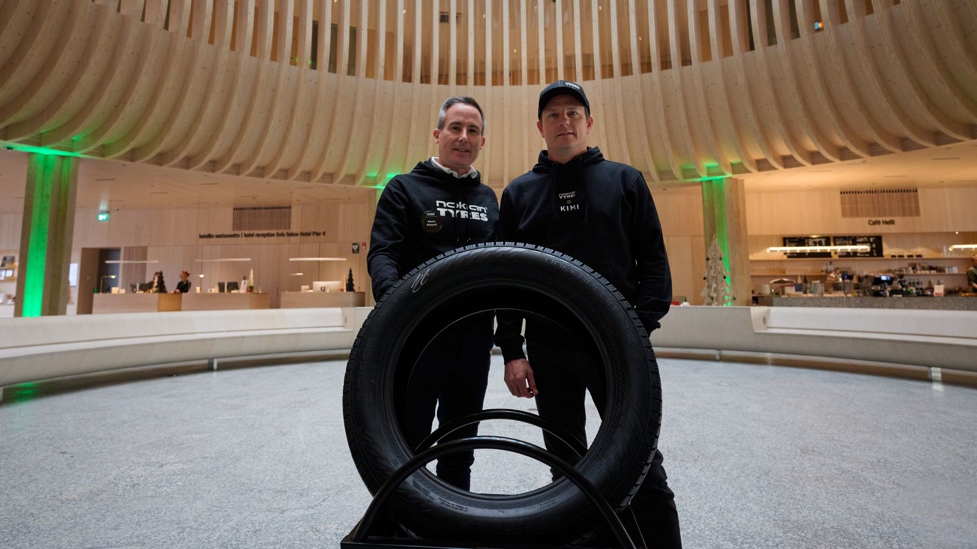 Kimi Räikkönen och Nokian Tyres representant vid ett lanseringsevent med däck i förgrunden