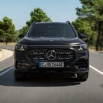 Eldrivna Mercedes GLB kör på landsväg i soligt landskap