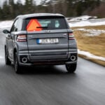 Mopedbil på blöt väg med snö på sidorna