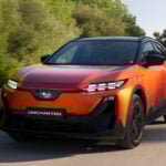 Orange Subaru Uncharted snett framifrån på landsväg.