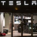 esla-showroom med flera bilar upplysta bakom glasfasad