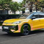 Gul Volkswagen T-Roc snett från sidan på väg i stadsmiljö.