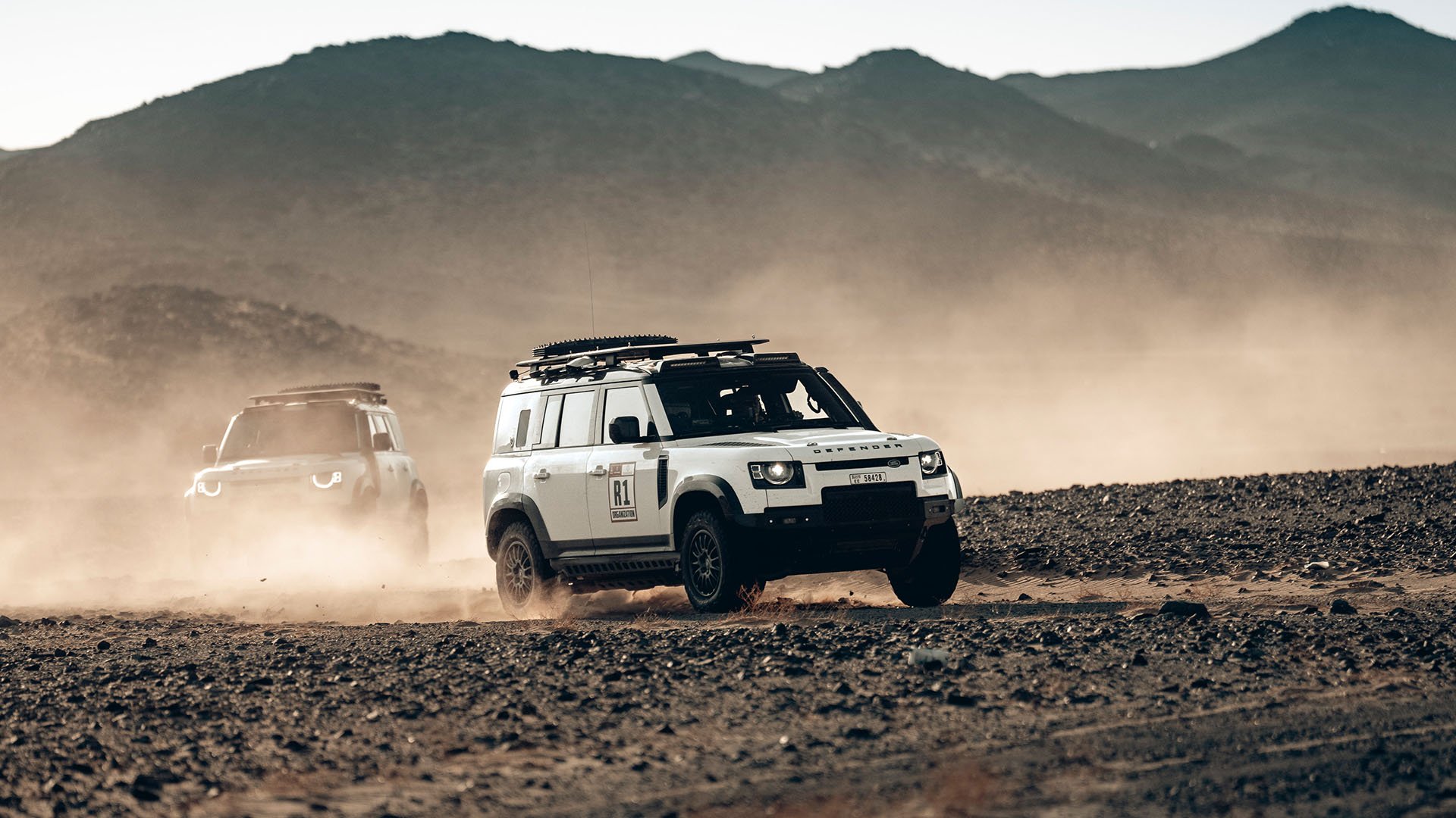Två Defender Dakar Recce i ökenmiljö.