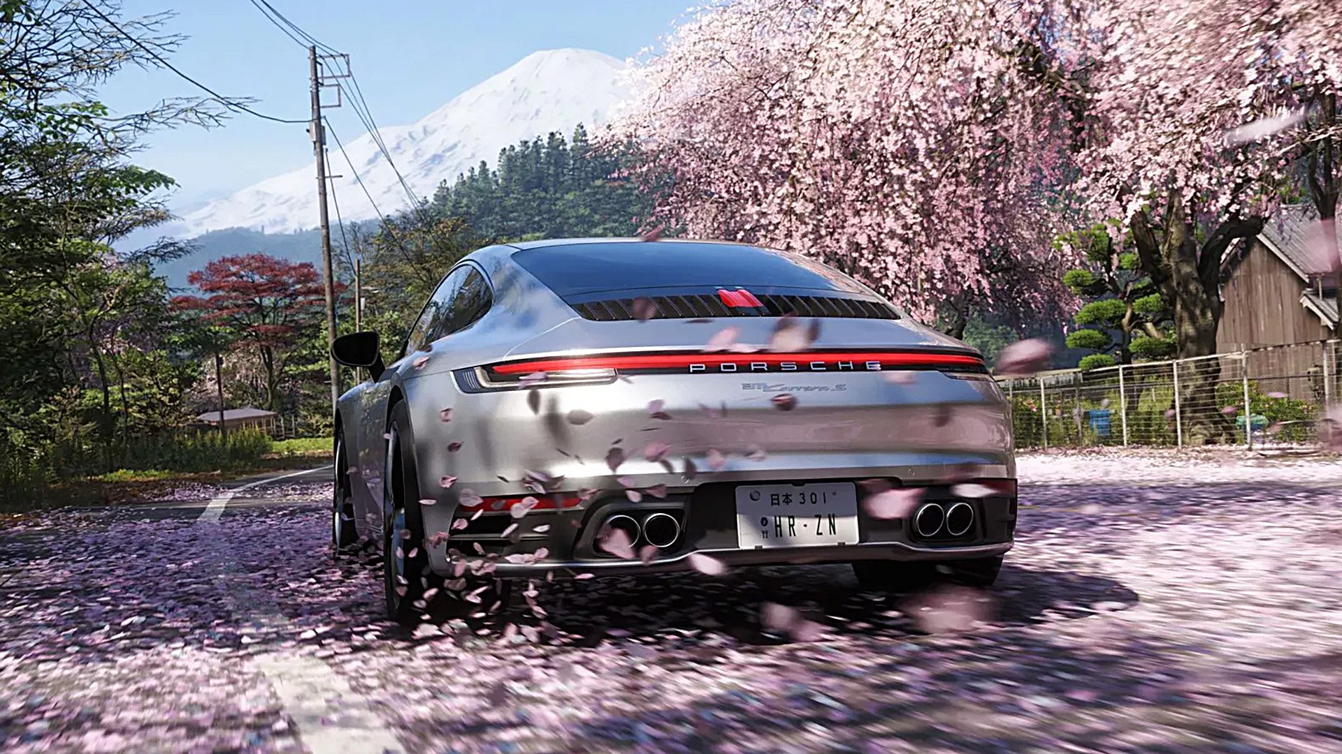 Porsche 911 bland blommande körsbärsträd och med Mount Fuji i bakgrunden.