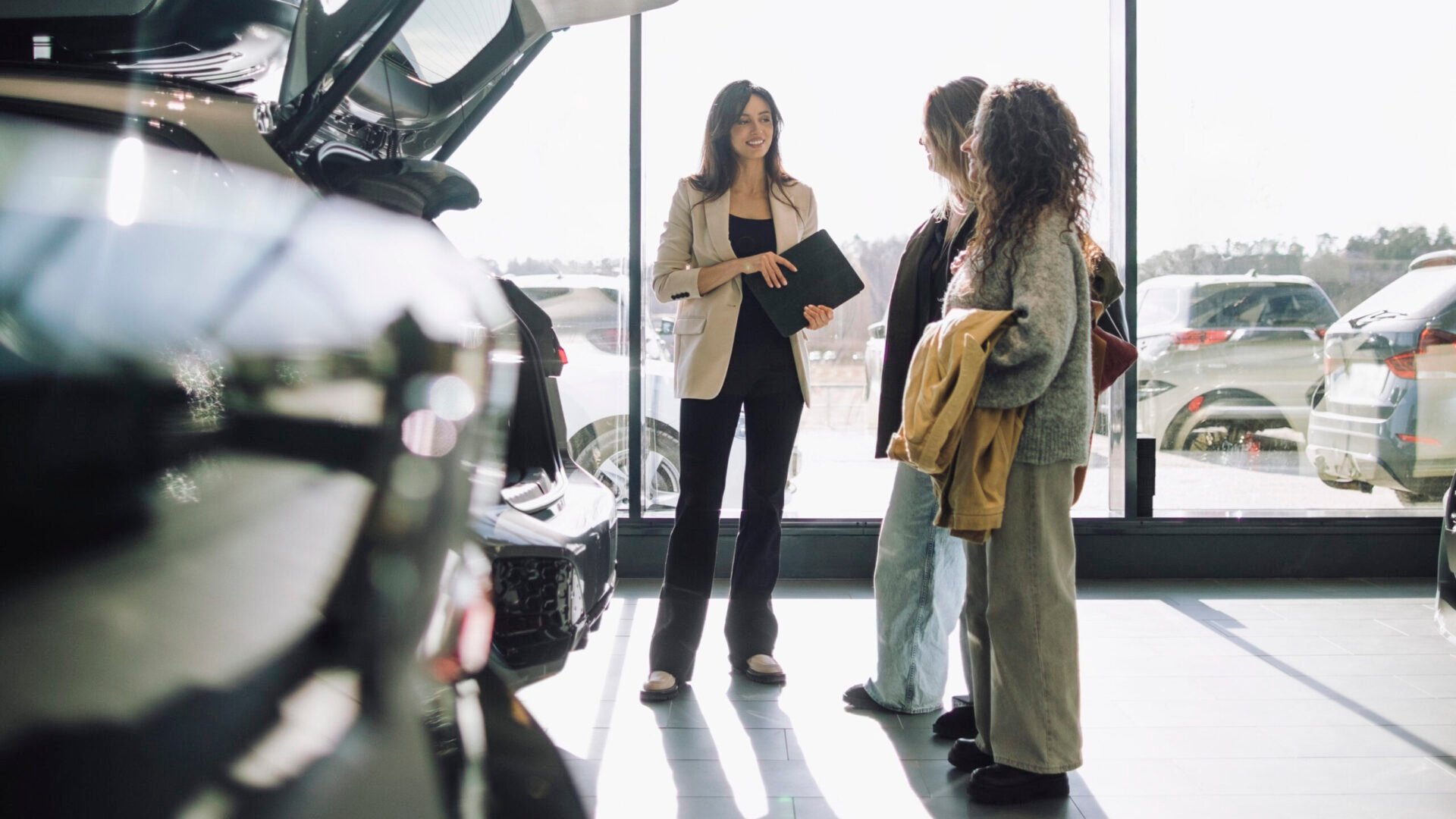 Två kunder och en bilförsäljare i en bihall