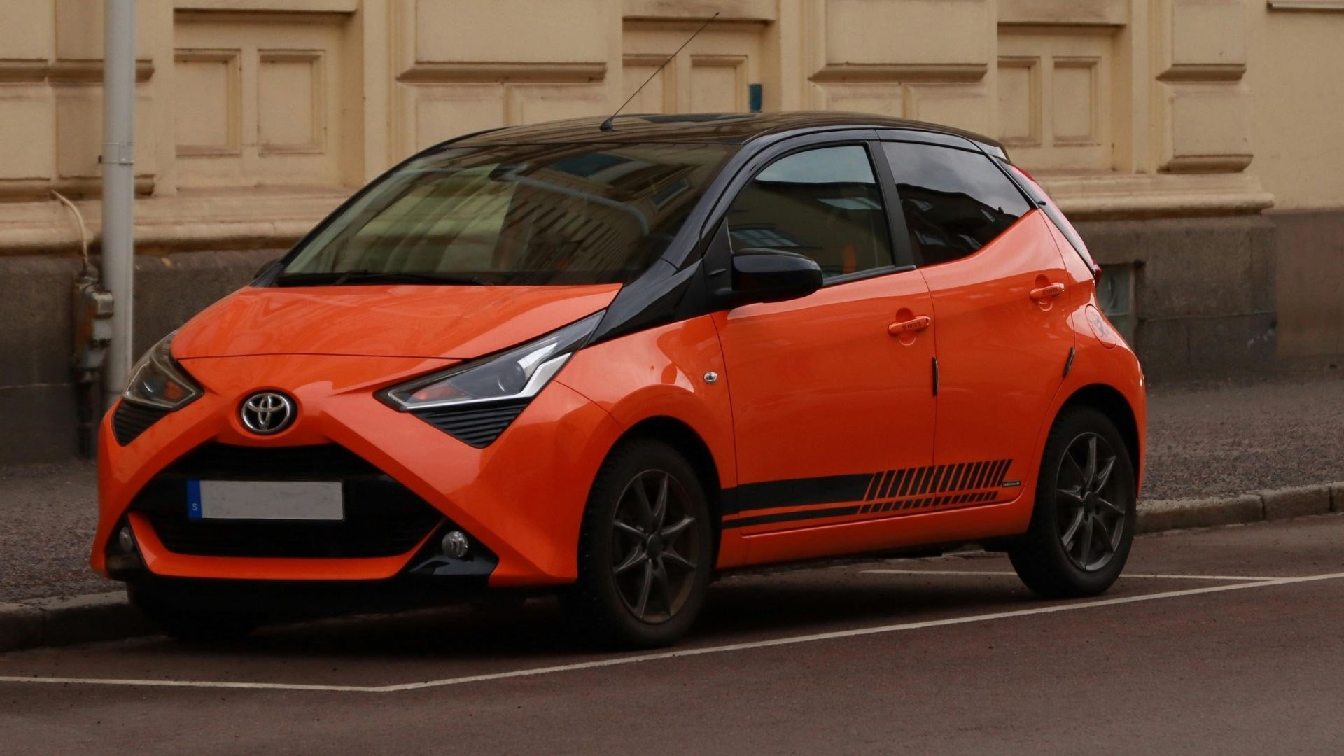 Orange bil i stadsmiljö som exempel på trenden mot mer personliga bilfärger i Sverige