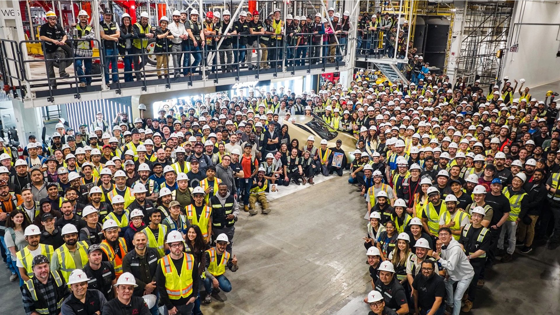 Bilbyggare tillsammans med det första exemplaret av Tesla Cybercab.