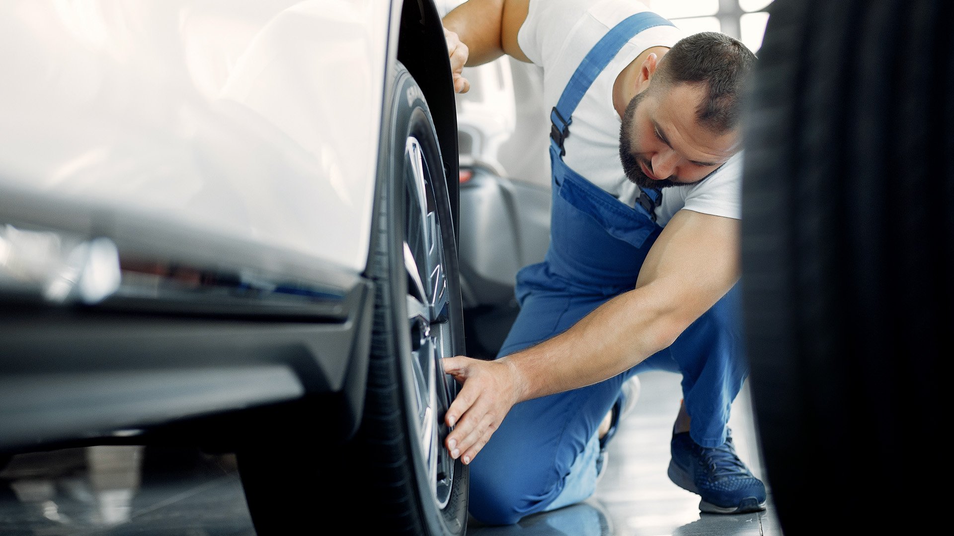 Man inspekterar däck och fälg