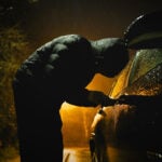 Tjuv som bryter sig in i bil.