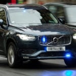Omålad civil Volvo XC90 polisbil under uttryckning.
