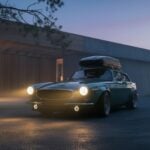 Volvo P1800 ES Norrsken restomod av Autoforma i mörkgrönt med takbox, breddade hjulhus och LED-dimljus framför skandinavisk arkitektur i skymning