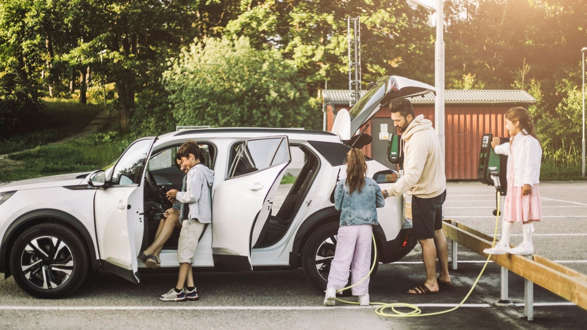 Familj laddar elbil vid publik laddstation i Stockholm