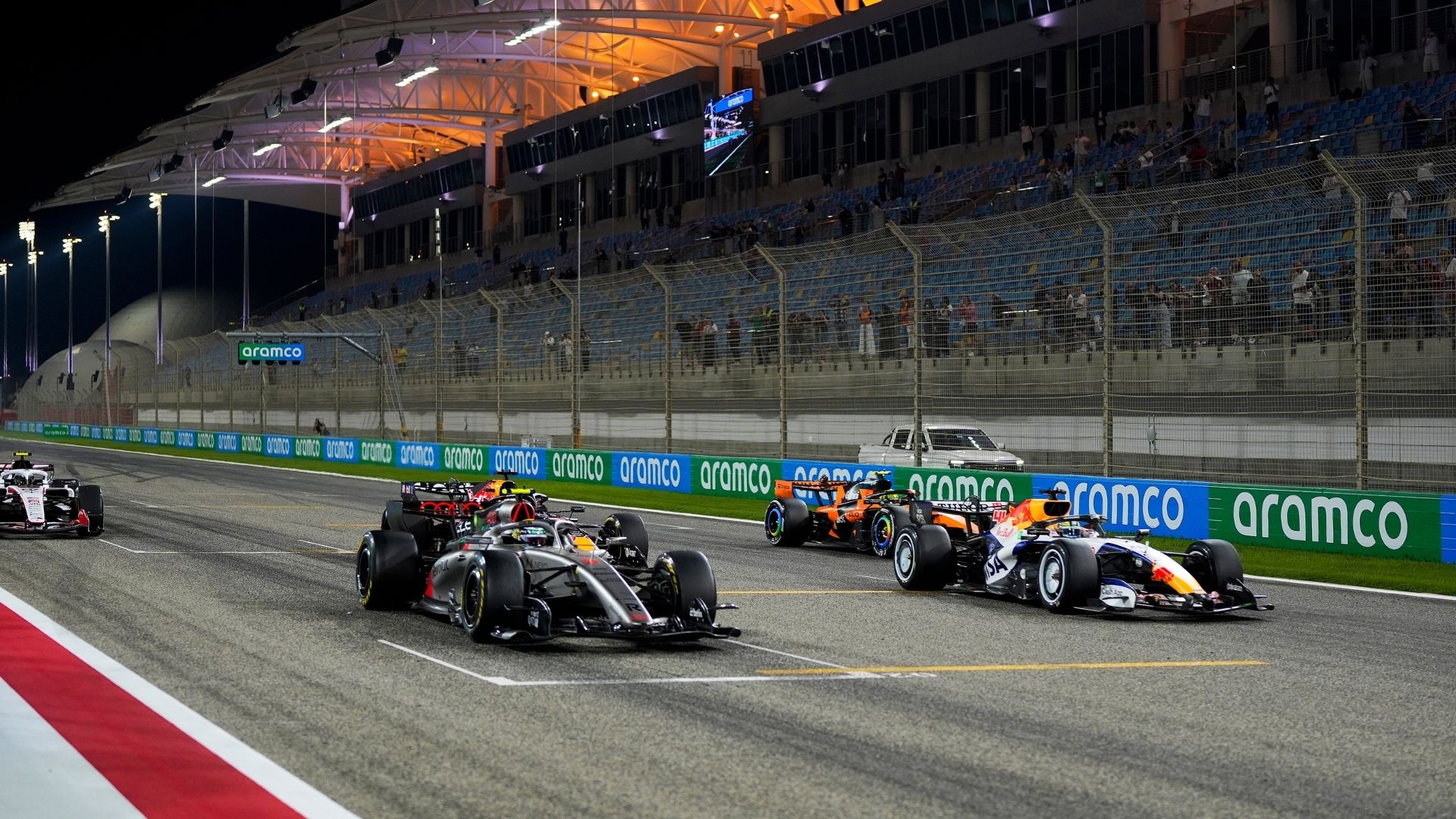 F1-bilar på Bahrain International Circuit under ett kvällsrace i Bahrain