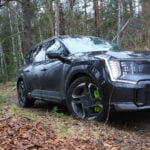 Grå Kia EV9 GT kör i terräng.