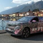 kamouflerad Skoda Peaq med sjö och berg i bakgrunden.