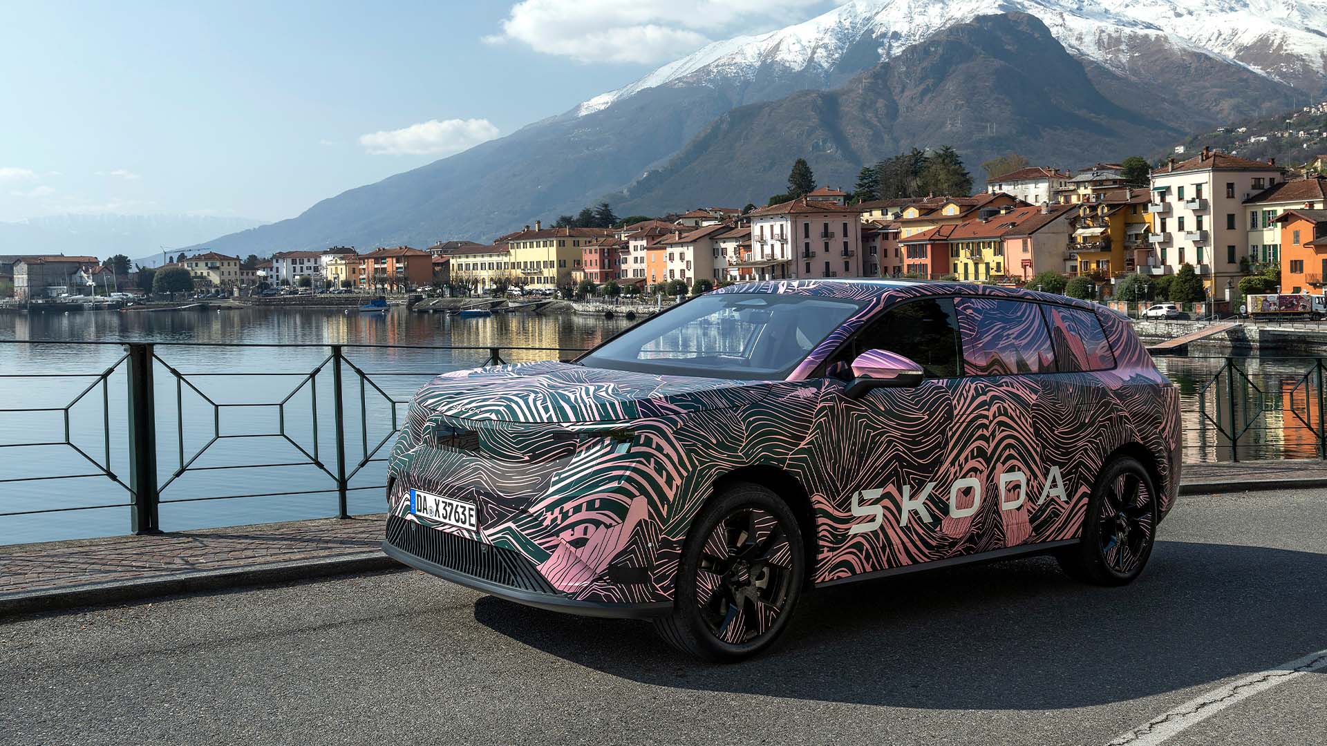 kamouflerad Skoda Peaq med sjö och berg i bakgrunden.