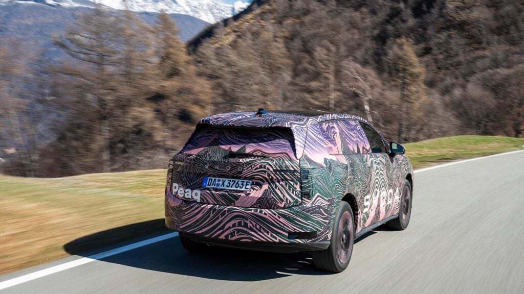 Kamouflerad Skoda Peaq snett bakifrån på landsväg.