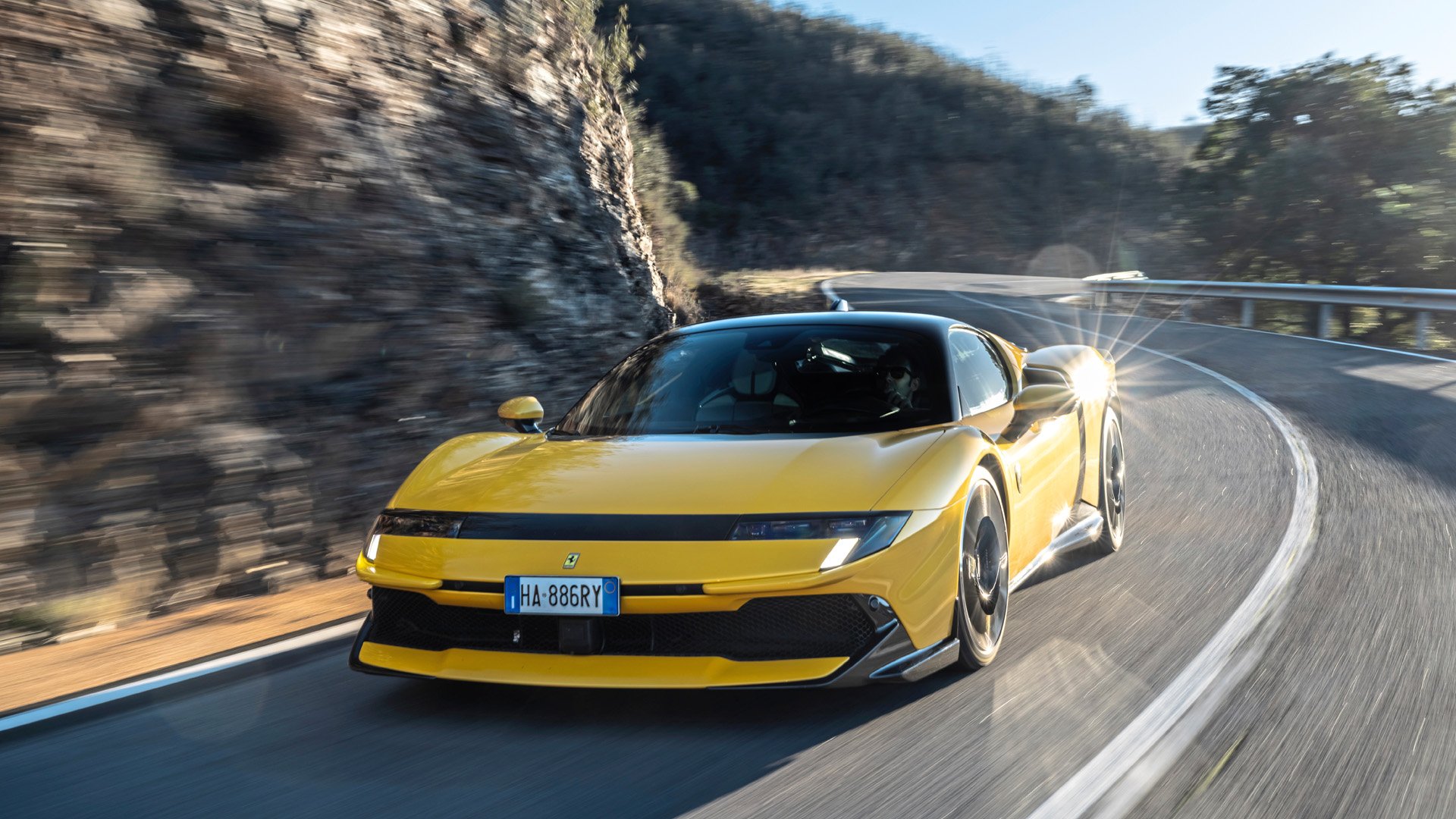 Ferrari 849 Testarossa. I gult framifån på en kruvad väg.