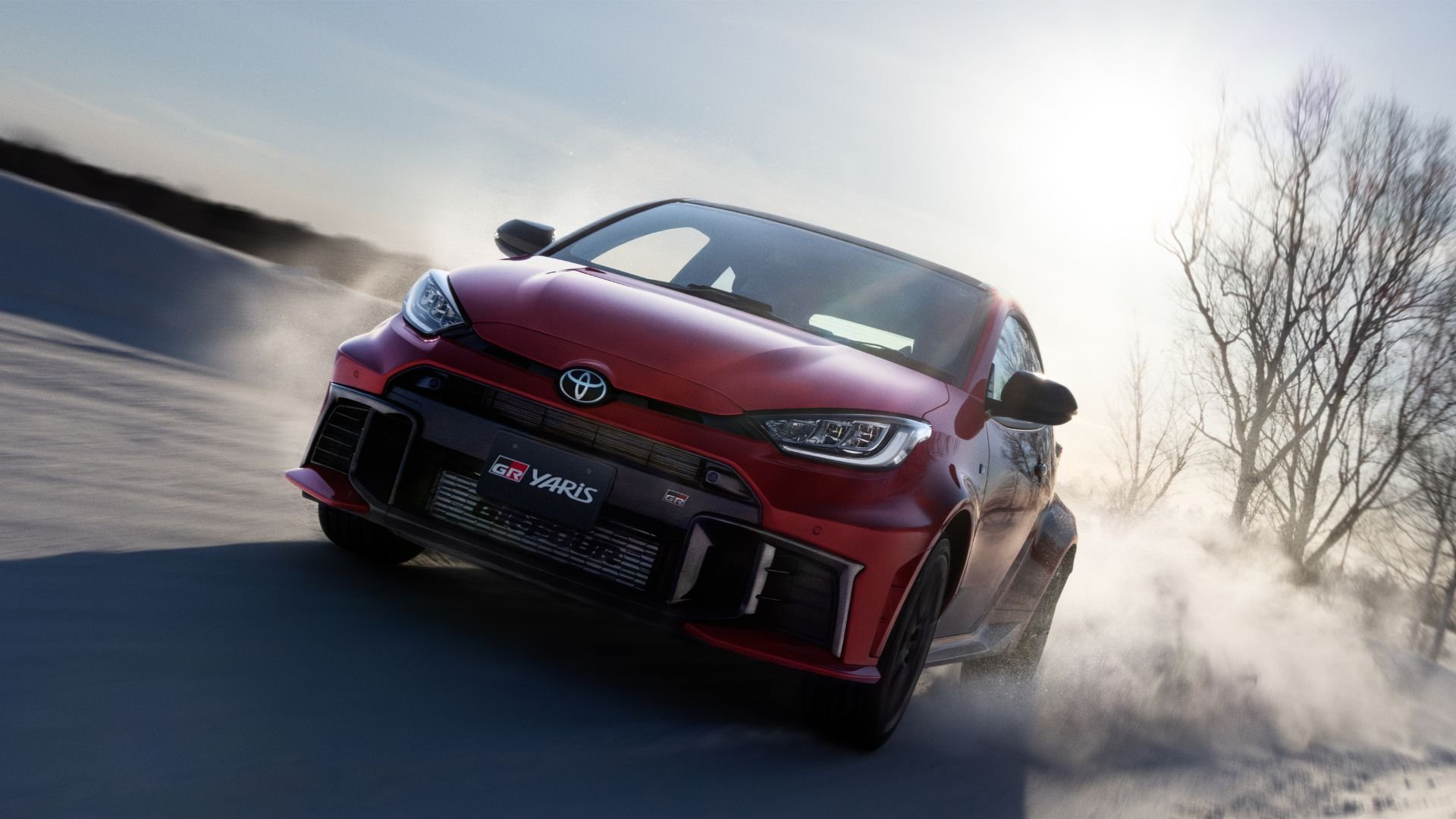 Röd Toyota GR Yaris kör på snötäckt väg