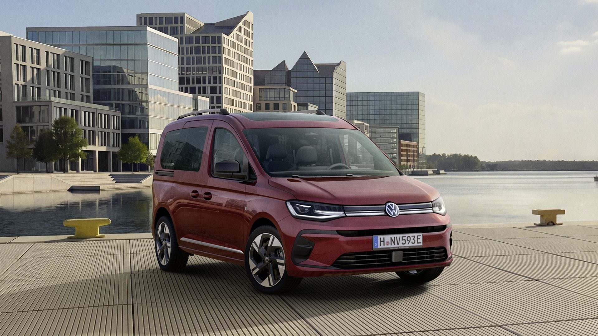 Vinröd Volkswagen Caddy modellår 2027 framför bostäder.