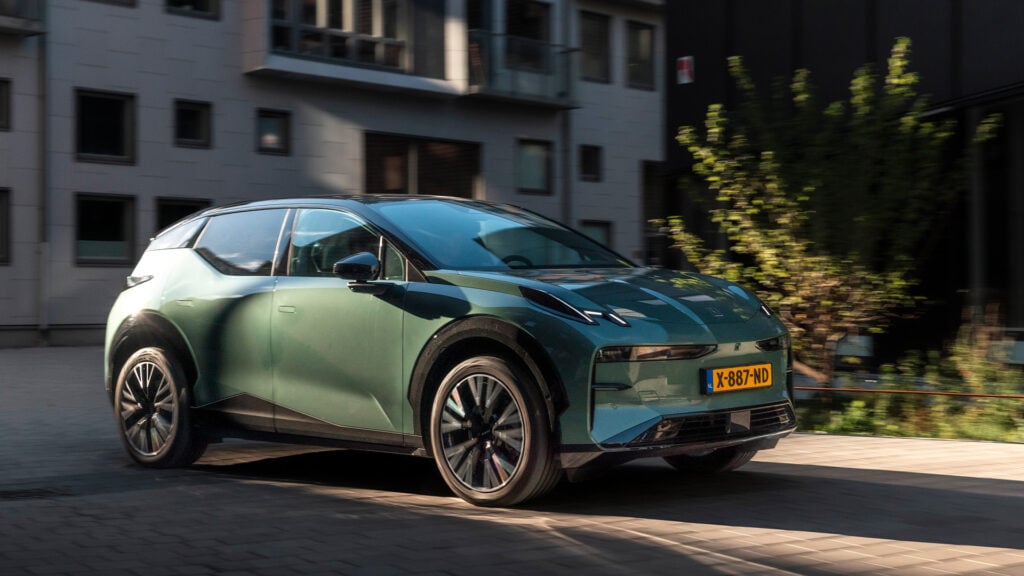 Grön Zeekr X snett framifrån i urban miljö.